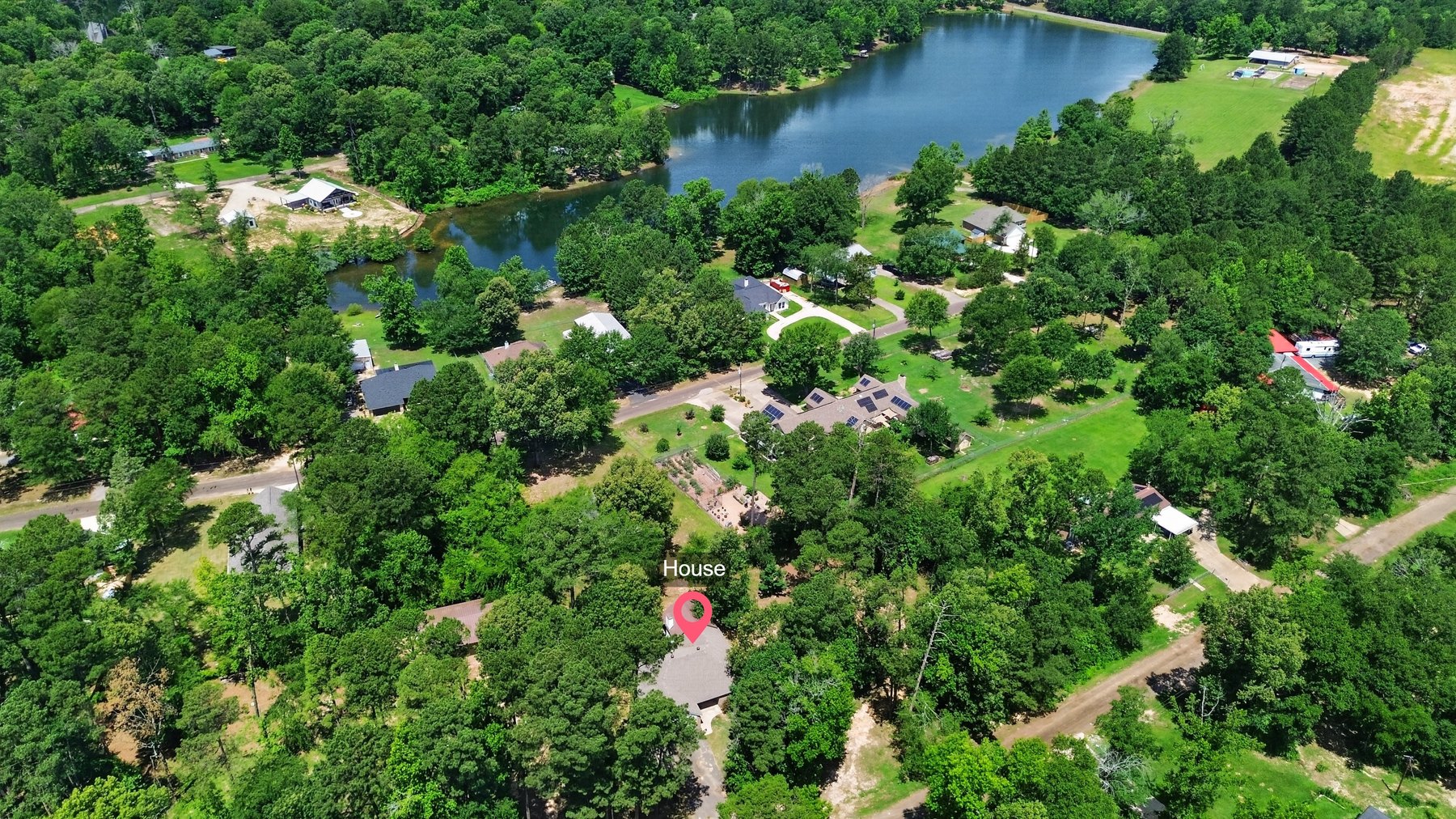 Aerial view showing 6110 Club Drive and nearby lake setting